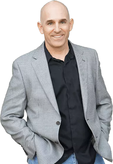 A smiling bald man, known as Brian Gibbs, a marketing strategist with a strong online presence, wearing a grey blazer and black shirt.