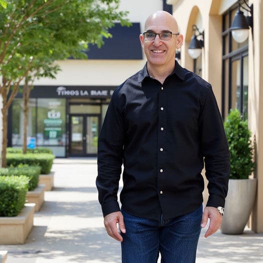 Brian Gibbs walking outdoors at an outdoor mall, approachable and professional